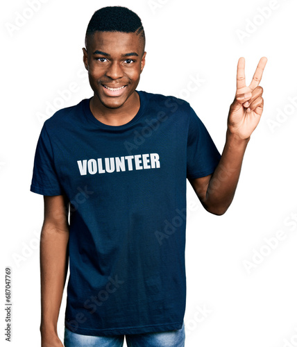 Young african american man wearing volunteer t shirt smiling looking to the camera showing fingers doing victory sign. number two.