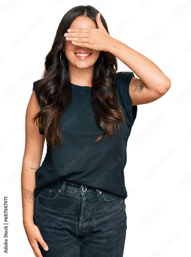 Beautiful brunette young woman wearing black shirt smiling and laughing with hand on face covering eyes for surprise. blind concept. Beautiful brunette young woman wearing black shirt smiling and laughing with hand on face covering eyes for surprise. blind concept.