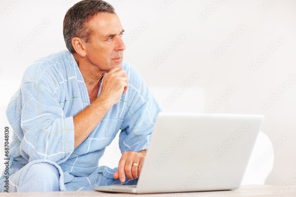 Thinking, morning and mature man on laptop for email, social media or streaming subscription on sofa. Internet search, couch and senior person on computer, website or networking ideas in living room. Thinking, morning and mature man on laptop for email, social media or streaming subscription on sofa. Internet search, couch and senior person on computer, website or networking ideas in living room.