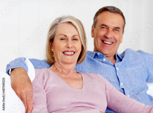 Elderly, couple and portrait or happy on sofa with support, relationship and marriage in retirement home. Senior, man and woman with smile on couch in living room with trust, care and love in house