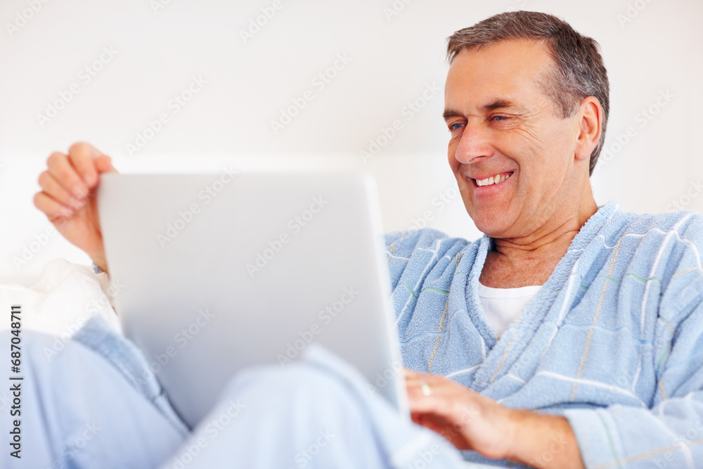 Bathrobe, relax and mature man on laptop for email, social media or streaming subscription on sofa. Internet search, couch and happy senior person on computer, website or networking in living room. Bathrobe, relax and mature man on laptop for email, social media or streaming subscription on sofa. Internet search, couch and happy senior person on computer, website or networking in living room.