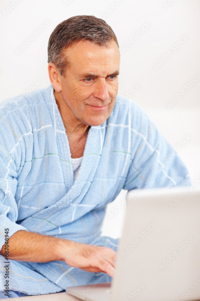 Bathrobe, relax and mature man on laptop, checking email, social media or streaming subscription on sofa. Internet website, couch and senior person on computer, morning and networking in living room. Bathrobe, relax and mature man on laptop, checking email, social media or streaming subscription on sofa. Internet website, couch and senior person on computer, morning and networking in living room.