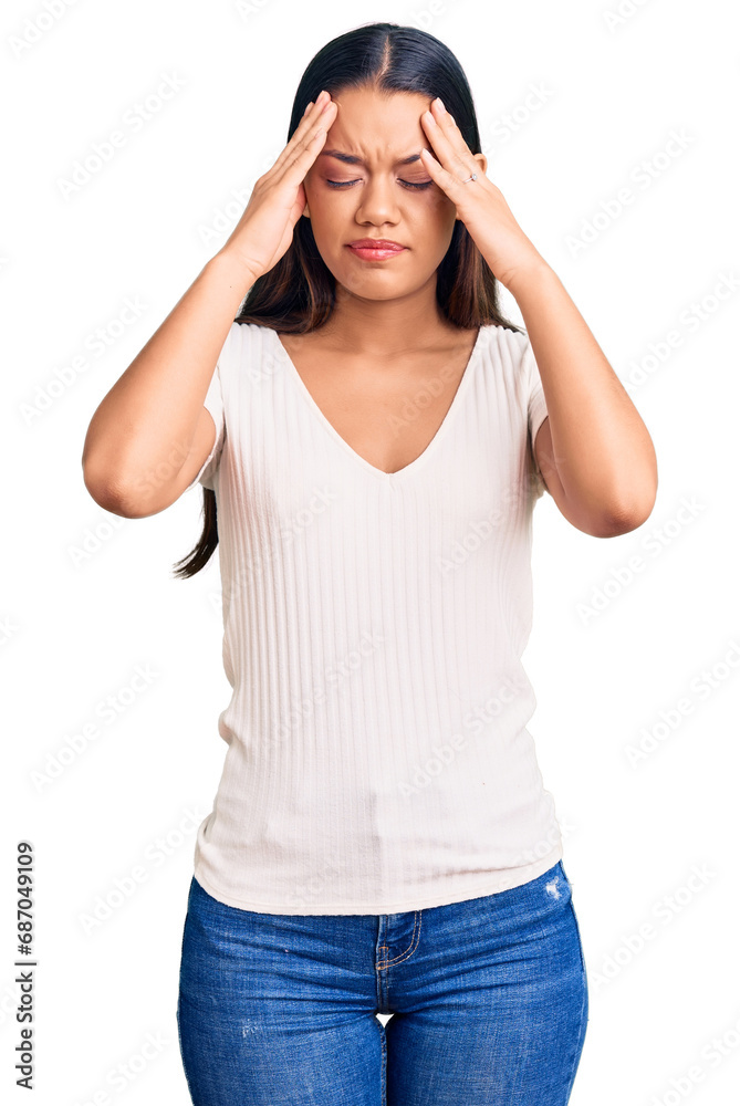 Young beautiful latin girl wearing casual white t shirt suffering from headache desperate and stressed because pain and migraine. hands on head. Young beautiful latin girl wearing casual white t shirt suffering from headache desperate and stressed because pain and migraine. hands on head.