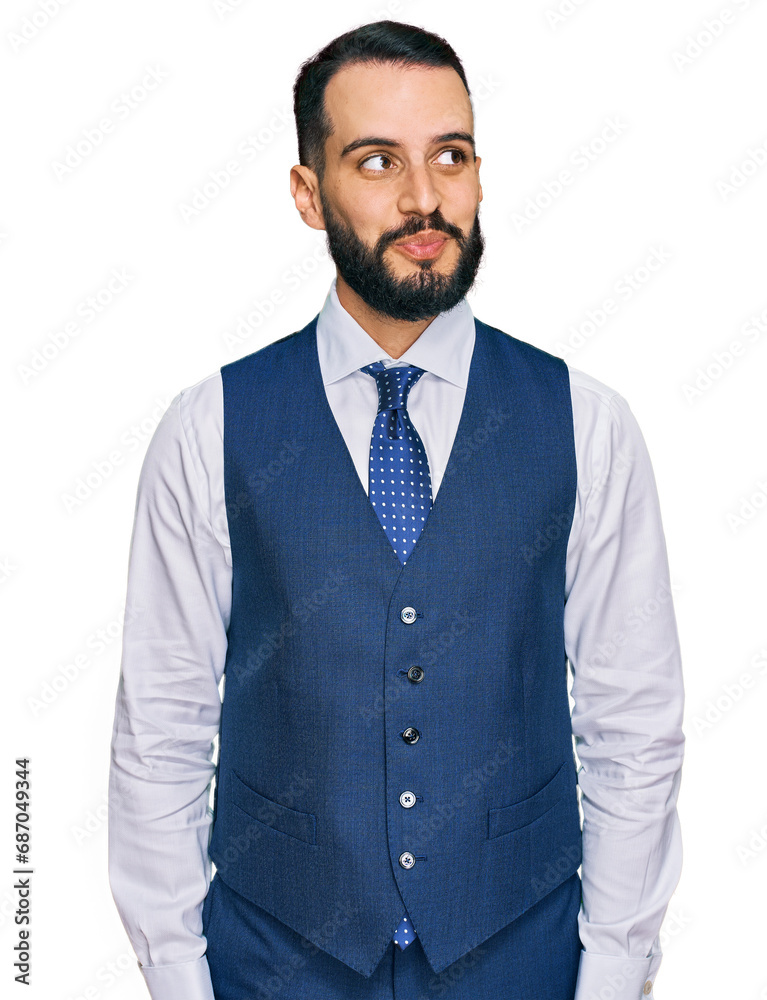 Young man with beard wearing business vest smiling looking to the side and staring away thinking. Young man with beard wearing business vest smiling looking to the side and staring away thinking.