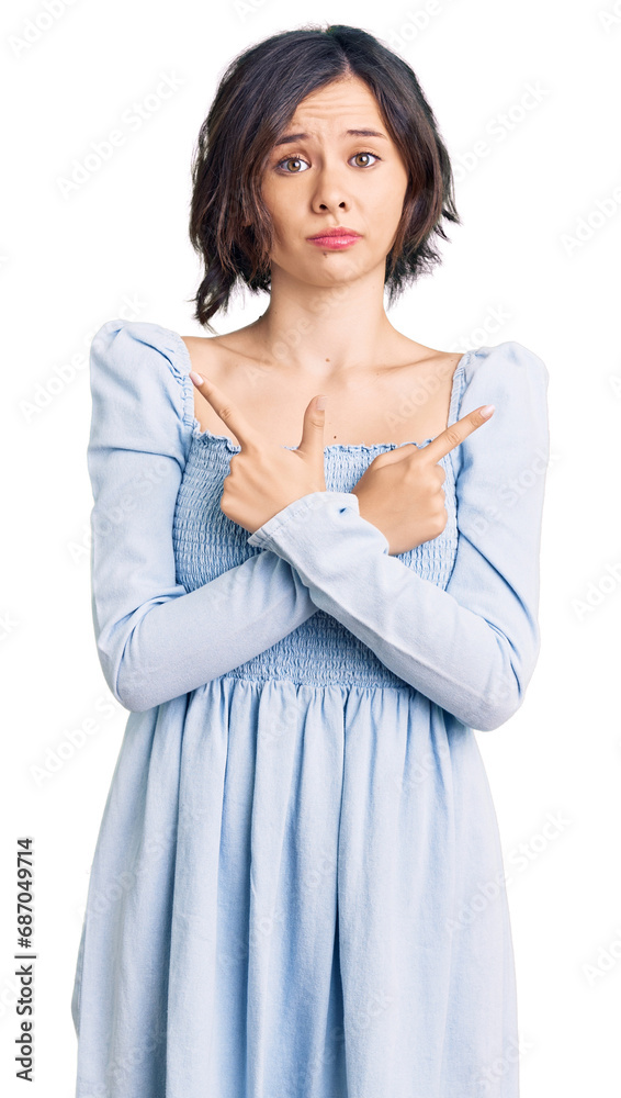 Young beautiful girl wearing casual clothes pointing to both sides with fingers, different direction disagree