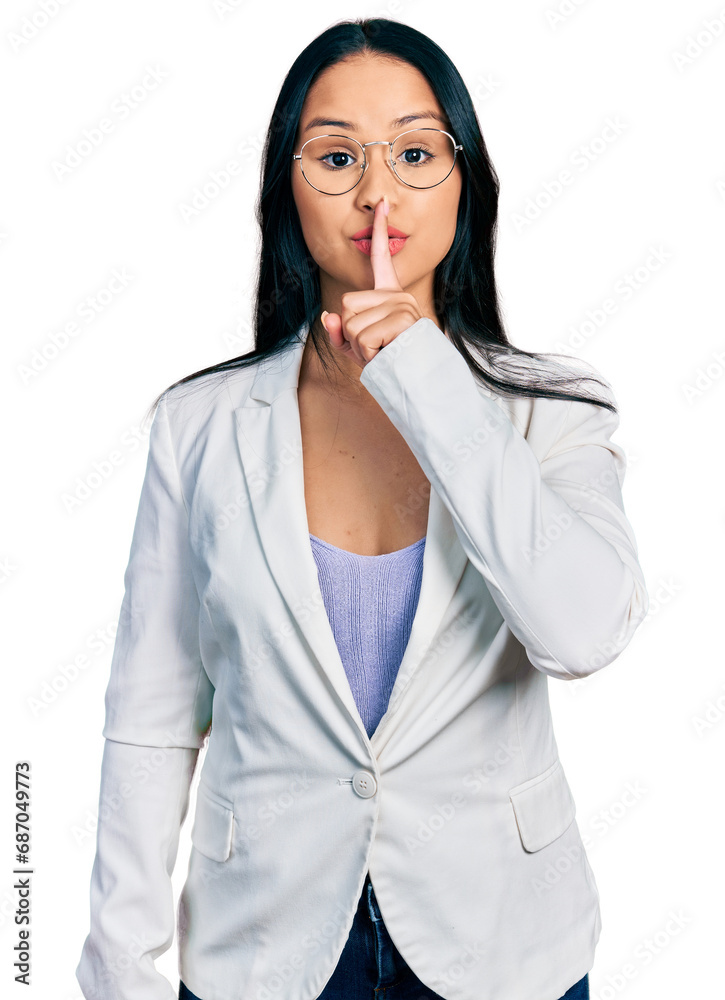 Beautiful hispanic woman with nose piercing wearing business jacket and glasses asking to be quiet with finger on lips. silence and secret concept.