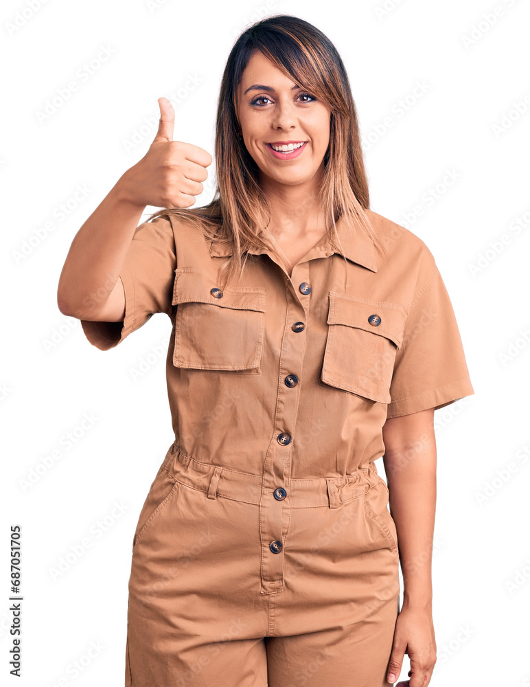 Young beautiful woman wearing casual dress smiling happy and positive, thumb up doing excellent and approval sign