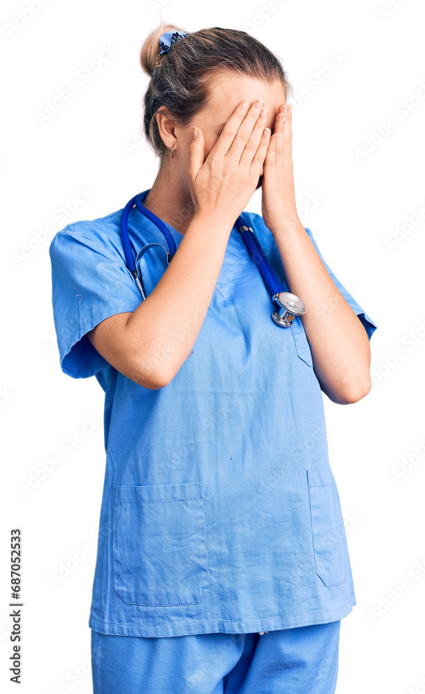 Young beautiful blonde woman wearing doctor uniform and stethoscope with sad expression covering face with hands while crying. depression concept. Young beautiful blonde woman wearing doctor uniform and stethoscope with sad expression covering face with hands while crying. depression concept.