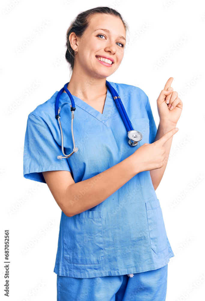 Young beautiful blonde woman wearing doctor uniform and stethoscope smiling and looking at the camera pointing with two hands and fingers to the side. Young beautiful blonde woman wearing doctor uniform and stethoscope smiling and looking at the camera pointing with two hands and fingers to the side.