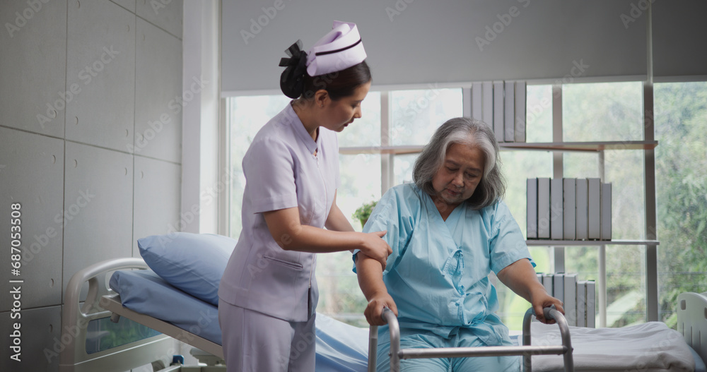 Portrait of Young nurse caring for an elderly woman to walk with a walker at the hospital. Healthcare, Retirement, Volunteer, Caregiver and Lifestyle concept