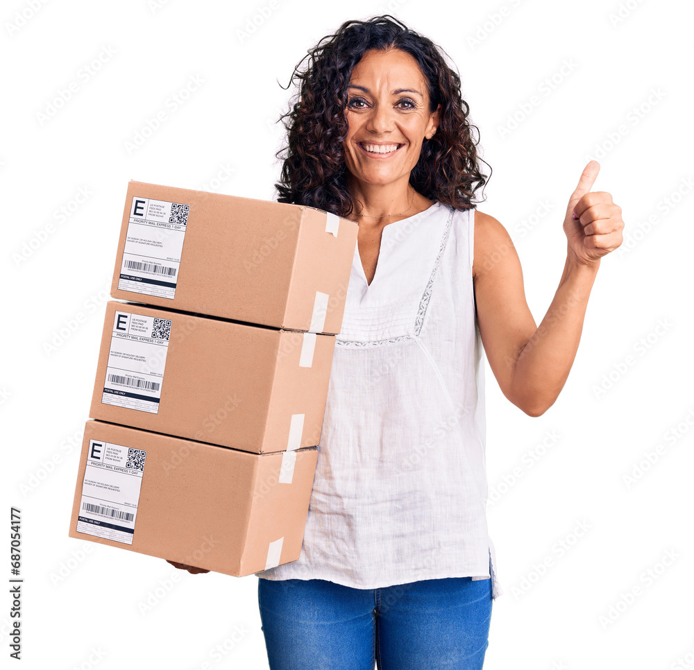 Middle age beautiful woman holding delivery package smiling happy and positive, thumb up doing excellent and approval sign Middle age beautiful woman holding delivery package smiling happy and positive, thumb up doing excellent and approval sign