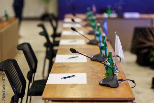 Canvas Print Empty convention center set up with gooseneck microphones, tables, chairs, water