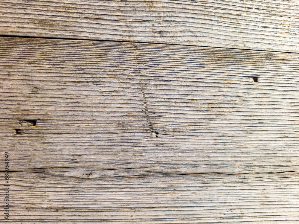 Fototapeta premium The wall of old boards natural wood. Weathered planks with a diagonal pattern. The tree darkened under the sun.