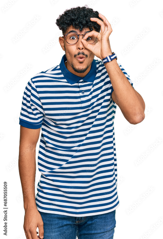 Young arab man wearing casual clothes and glasses doing ok gesture shocked with surprised face, eye looking through fingers. unbelieving expression. Young arab man wearing casual clothes and glasses doing ok gesture shocked with surprised face, eye looking through fingers. unbelieving expression.