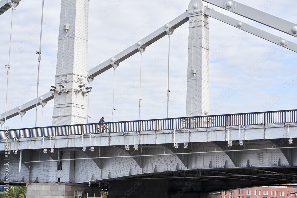 Man riding on bicycle across the bridge in the city. Man riding on bicycle across the bridge in the city.