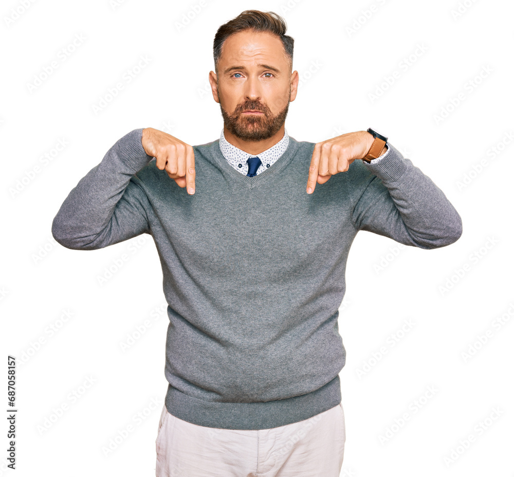 Handsome middle age man wearing business clothes pointing down looking sad and upset, indicating direction with fingers, unhappy and depressed. Handsome middle age man wearing business clothes pointing down looking sad and upset, indicating direction with fingers, unhappy and depressed.