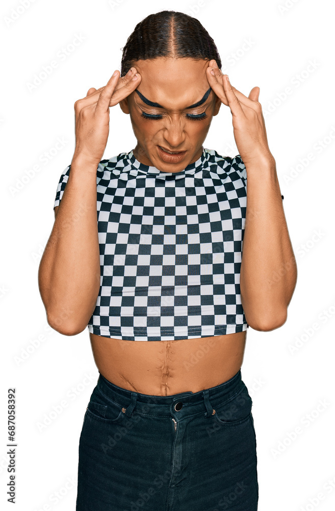 Hispanic transgender man wearing make up and long hair wearing modern clothes with hand on head for pain in head because stress. suffering migraine. Hispanic transgender man wearing make up and long hair wearing modern clothes with hand on head for pain in head because stress. suffering migraine.