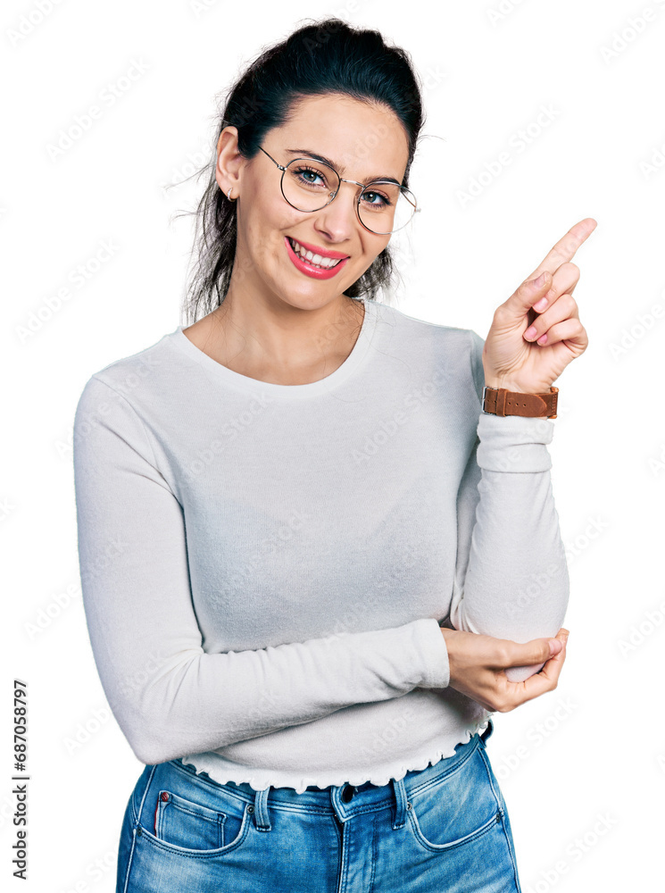 Young hispanic woman wearing casual clothes with a big smile on face, pointing with hand and finger to the side looking at the camera.