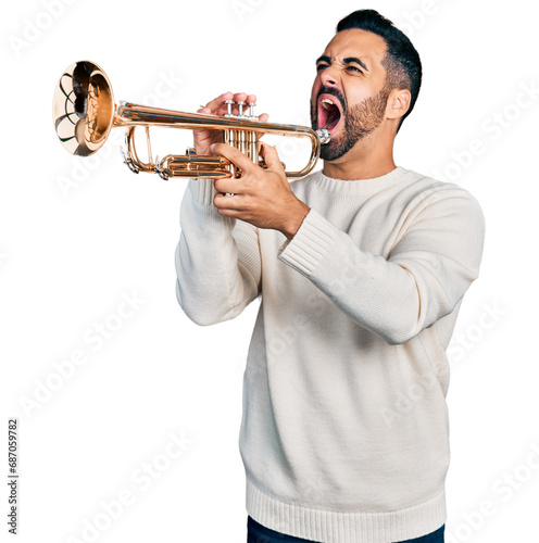 Young hispanic man with beard playing trumpet angry and mad screaming frustrated and furious  shouting with anger. rage and aggressive concept.