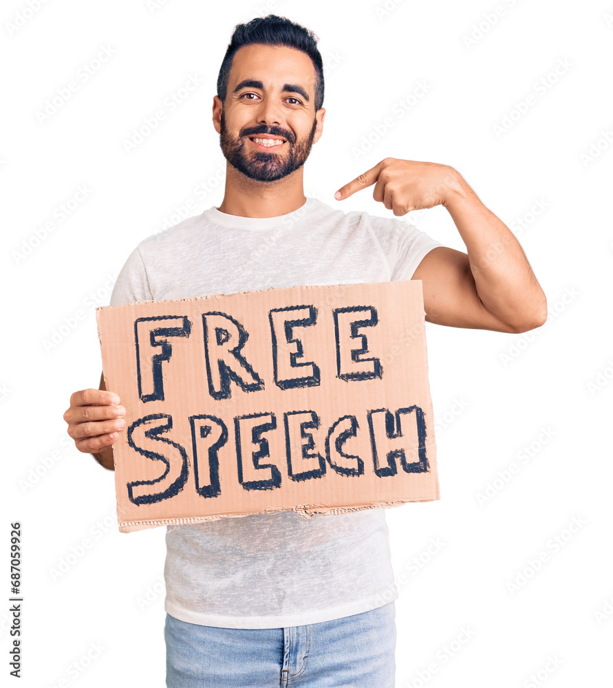 Young hispanic man holding free speech banner pointing finger to one self smiling happy and proud Young hispanic man holding free speech banner pointing finger to one self smiling happy and proud