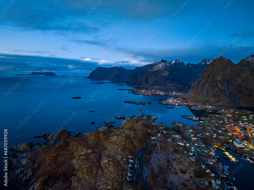 aerial view of lofoten islands coast with villages on the shore with red houses during sunrise