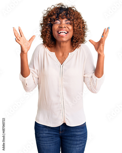 Young african american woman wearing casual clothes celebrating mad and crazy for success with arms raised and closed eyes screaming excited. winner concept