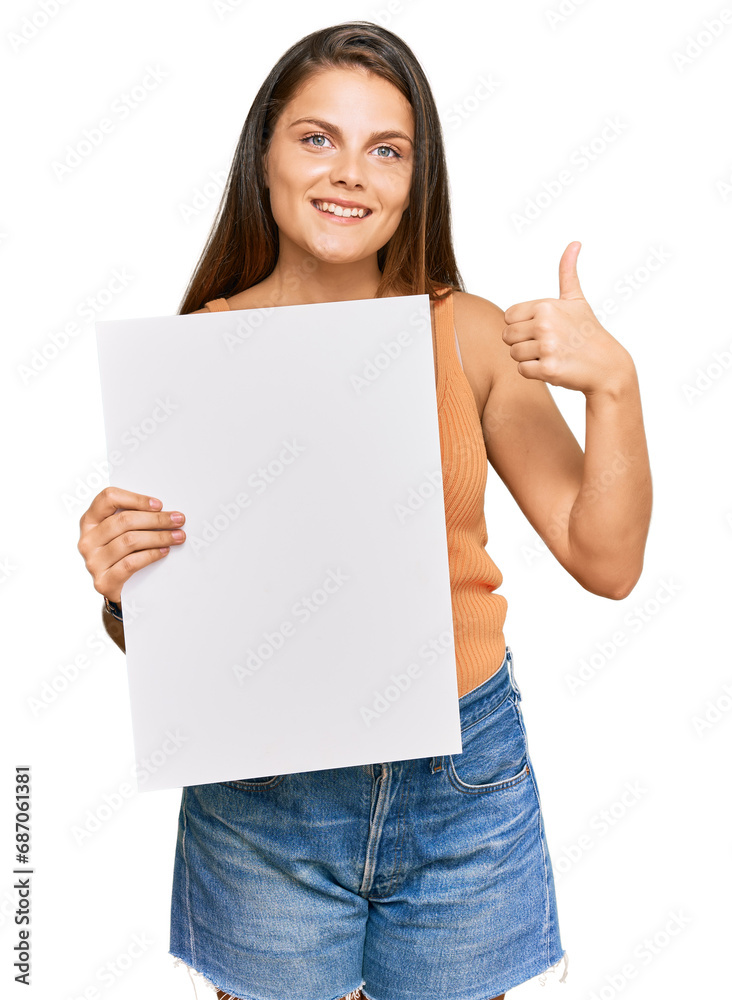 Young caucasian woman holding blank empty banner smiling happy and positive, thumb up doing excellent and approval sign Young caucasian woman holding blank empty banner smiling happy and positive, thumb up doing excellent and approval sign