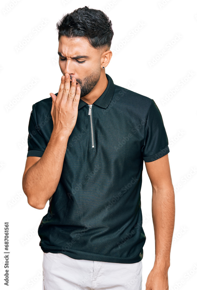 Young man with beard wearing sportswear bored yawning tired covering mouth with hand. restless and sleepiness. Young man with beard wearing sportswear bored yawning tired covering mouth with hand. restless and sleepiness.