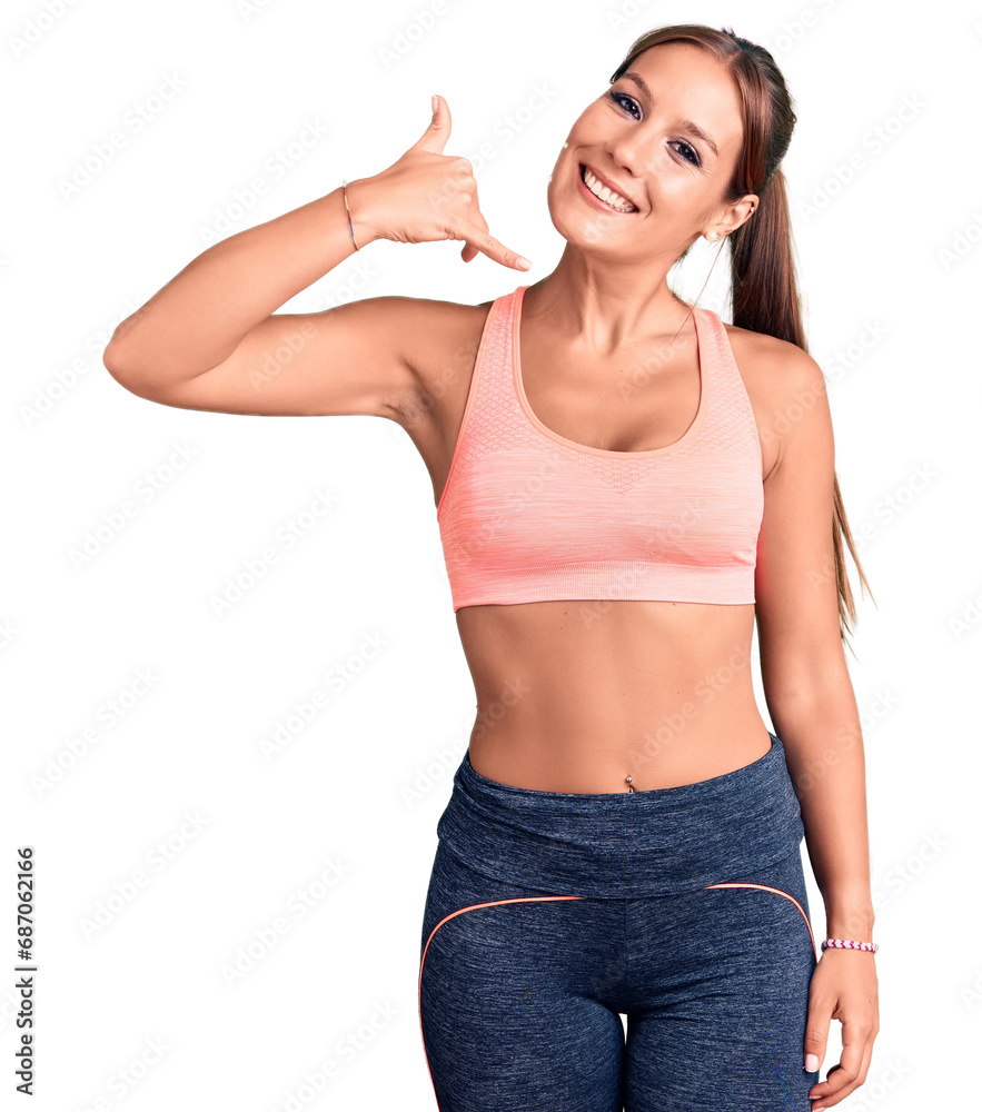 Young beautiful hispanic woman wearing sportswear smiling doing phone gesture with hand and fingers like talking on the telephone. communicating concepts.