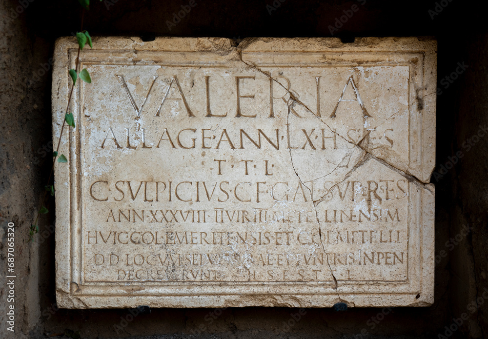 Roman inscription in marble from a funerary tombstone of Publius Valerius Laetus, which reads: Licensed soldier, 80 years old. Here it lies. May the earth be light to you.in Mérida Columbarios, Spain.