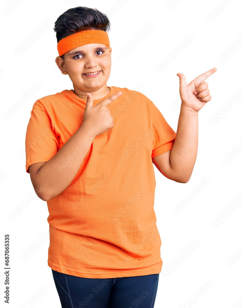 Little boy kid wearing sportswear smiling and looking at the camera pointing with two hands and fingers to the side. Little boy kid wearing sportswear smiling and looking at the camera pointing with two hands and fingers to the side.