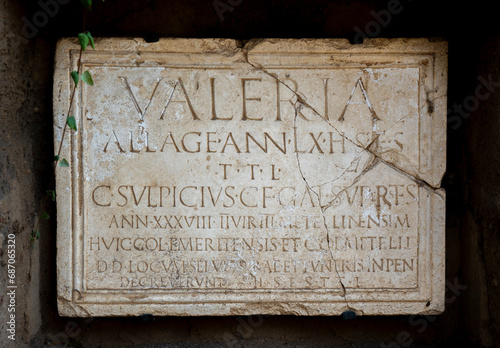 Roman inscription in marble from a funerary tombstone of Publius Valerius Laetus, which reads: Licensed soldier, 80 years old. Here it lies. May the earth be light to you.in Mérida Columbarios, Spain. photo