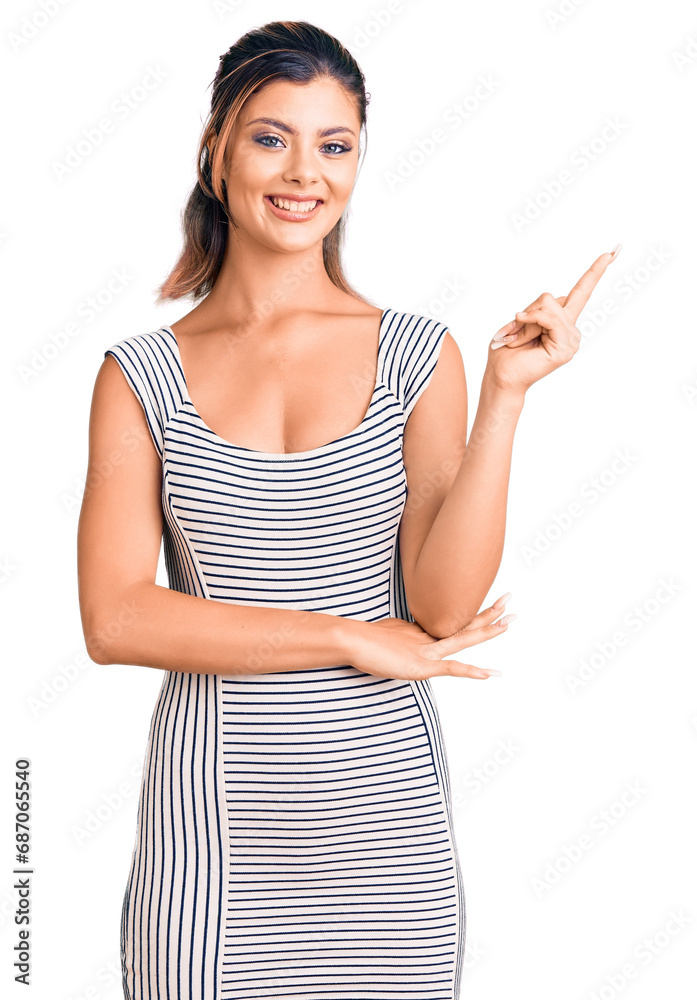 Young beautiful woman wearing casual dress smiling happy pointing with hand and finger to the side Young beautiful woman wearing casual dress smiling happy pointing with hand and finger to the side