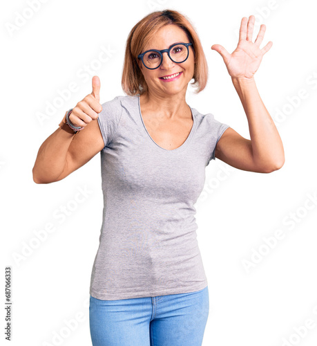 Young blonde woman wearing casual clothes showing and pointing up with fingers number six while smiling confident and happy.
