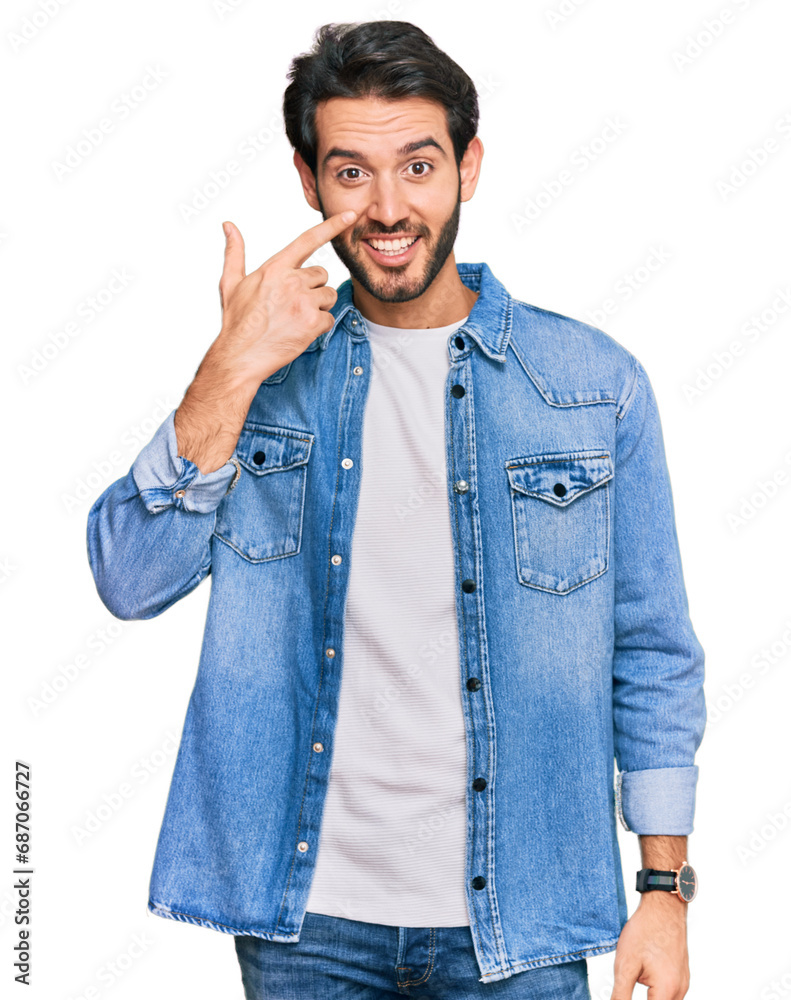 Young hispanic man wearing casual clothes pointing with hand finger to face and nose, smiling cheerful. beauty concept Young hispanic man wearing casual clothes pointing with hand finger to face and nose, smiling cheerful. beauty concept