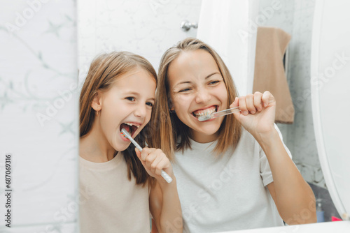 Mother and children brush their teeth in the bathroom.