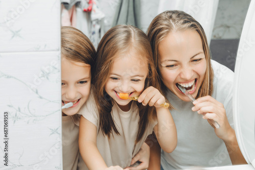 Mother and children brush their teeth in the bathroom. photo