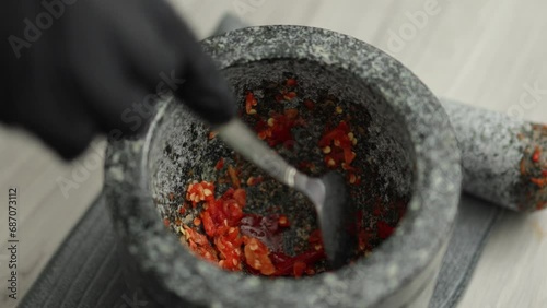 Chef prepares ingredients for Thai cooking by uses spoon to scoop out crushed chilies and garlic from the mortar stock video, Homemade cooking concept