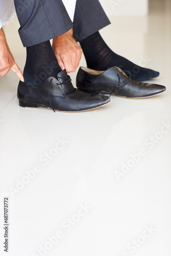Shoes, dressing and hands of business man in home getting ready for work, career and job. Corporate, morning routine and feet of worker prepare with trendy, professional fashion and formal style