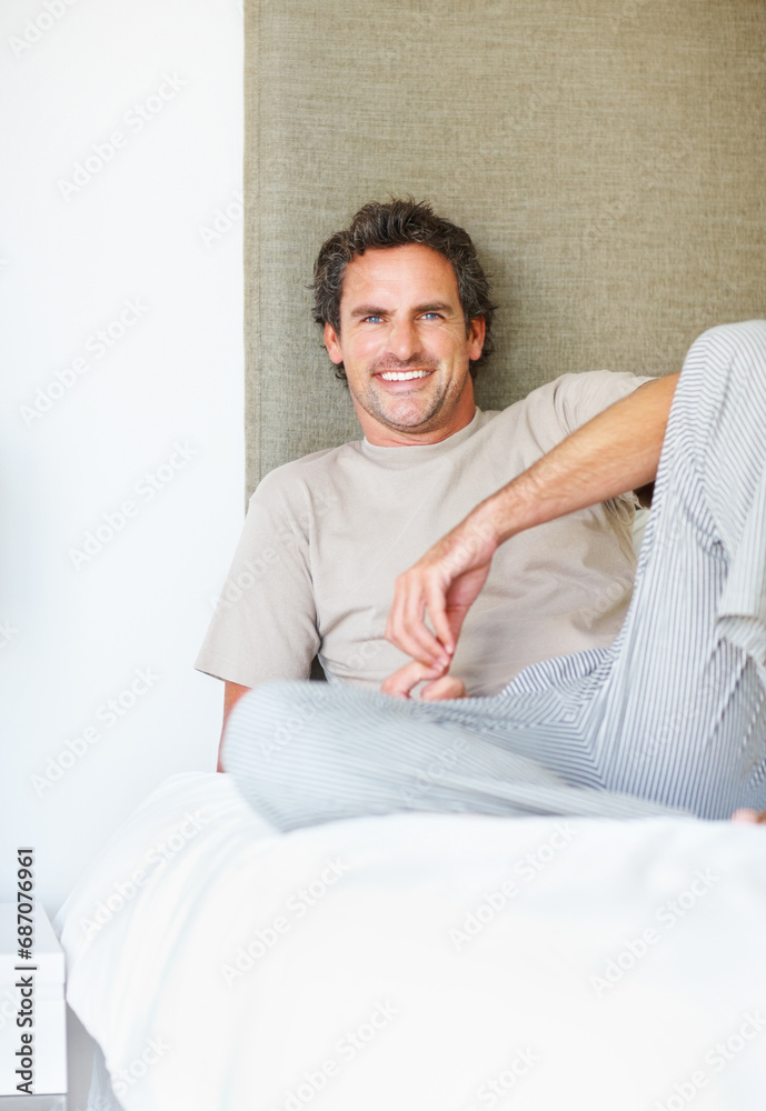 Portrait, happy or man relax in bed in the morning after nap, break or awake from comfortable sleep at home. Mature guy, smile or wake up in bedroom for healthy rest, routine or cozy day in apartment