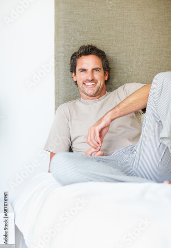 Portrait, happy or man relax in bed in the morning after nap, break or awake from comfortable sleep at home. Mature guy, smile or wake up in bedroom for healthy rest, routine or cozy day in apartment © STEEX/peopleimages.com
