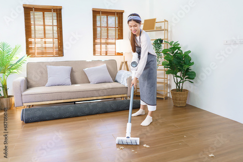 Hygiene cleaning concept, Housemaid use mop to mopping and cleaning dust on floor in living room