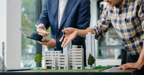 balancing the property sector The real estate agent is explaining the house style to see the house design and the purchase agreement. house city