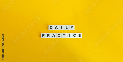 Daily Practice Text on Block Letter Tiles on Yellow Background. Minimalist Aesthetics. Strong Word Ethic, Commitment, and Self-discipline Concept. photo