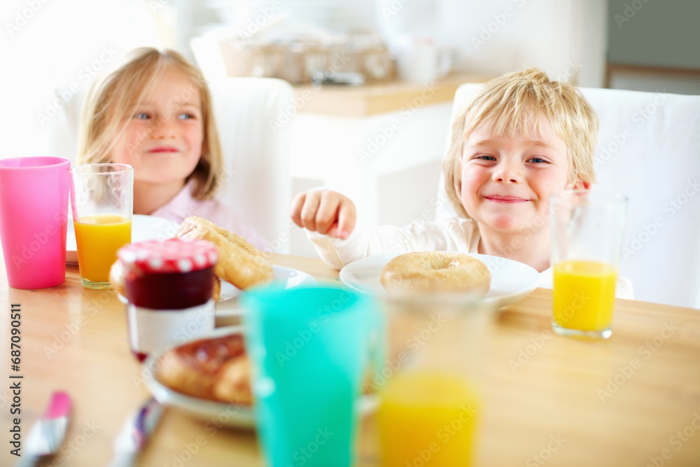 Smile, kitchen and children eating breakfast together for healthy, wellness and diet meal. Happy, laughing and kid siblings bonding and enjoying lunch or brunch with juice at table in family home. Smile, kitchen and children eating breakfast together for healthy, wellness and diet meal. Happy, laughing and kid siblings bonding and enjoying lunch or brunch with juice at table in family home.