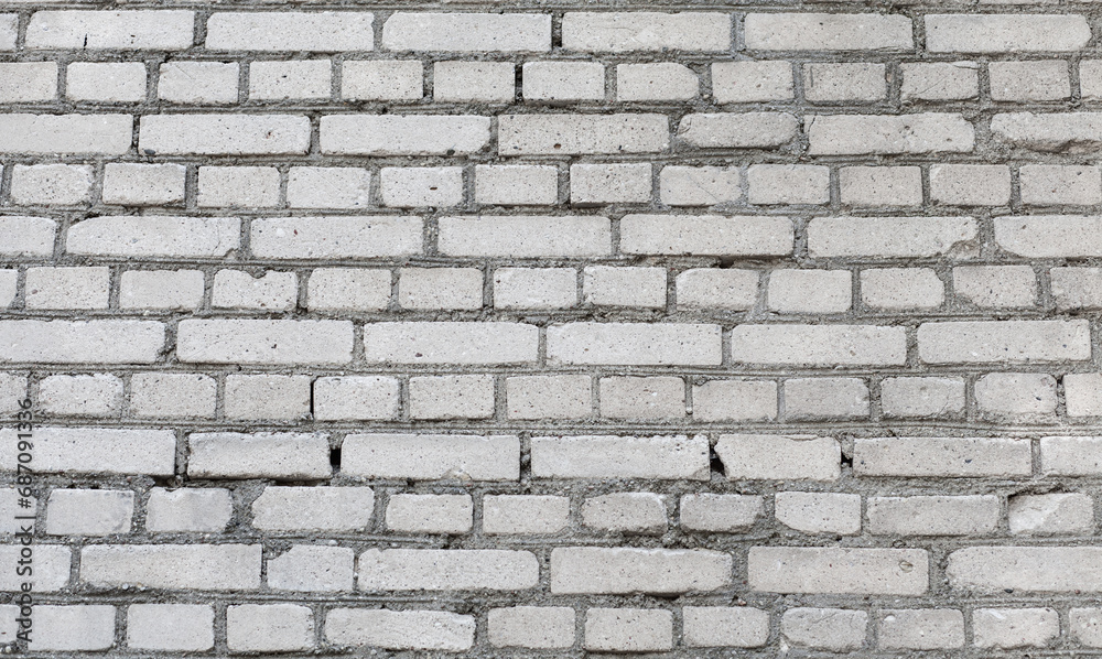 Fototapeta premium Old grey brick wall background. Rough brick wall texture. Abstract grey brick wall surface. Close up.