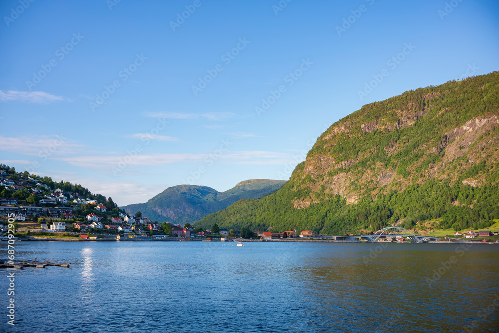 Golden hour at Sogndal, a village Vestland county, Norway near a body of water, shown here with a motorboat.