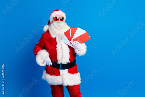 Photo portrait of mature pensioner man hold advert flyers dressed stylish santa claus costume coat isolated on blue color background