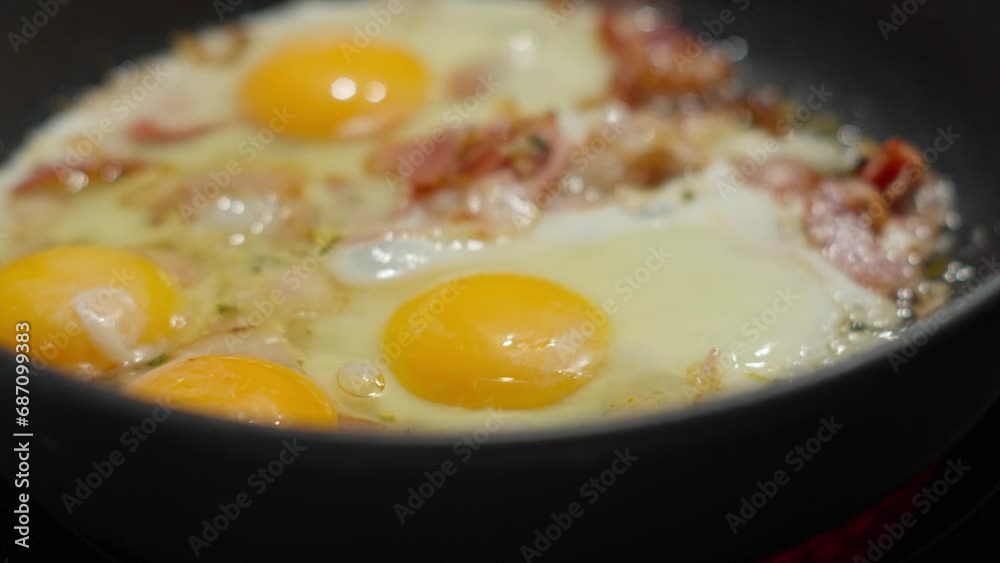 Eggs and Bacon Sizzling in a Skillet on the Stove. Selective focus Eggs and Bacon Sizzling in a Skillet on the Stove. Selective focus