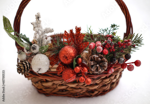 Basket with Christmas decorations on white background